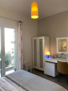 1 dormitorio con 1 cama y baño con lavamanos en Zoe Pension, en Ermioni