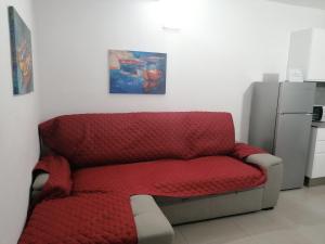 a red couch in a kitchen with a painting on the wall at Vivienda El Remo-Vv-3 in Los Llanos de Aridane