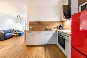 eine Küche mit weißen Schränken und einem roten Kühlschrank in der Unterkunft Winderatt Wohnung 2 in Husby