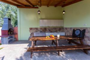 une cuisine extérieure avec une table en bois et une cuisinière dans l'établissement Elegant Villa Versovica with pool near Pula, à Peruški