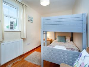 a bedroom with a blue bunk bed and a window at Barn Owl - Uk44607 in Carnbrea