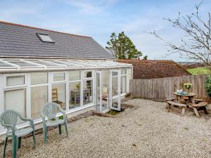 a conservatory with a table and chairs and a picnic table at Barn Owl - Uk44607 in Carnbrea