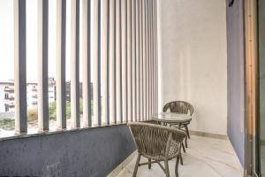 a table and two chairs sitting in front of a window at Hotel RJ - Managed by AHG in Greater Noida