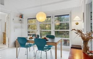 comedor con mesa de madera y sillas azules en Amazing Home In Vig With Kitchen, en Vig