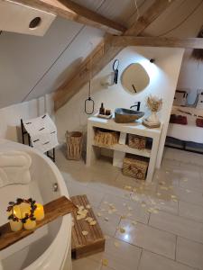 ein Bad mit einer Badewanne und einem Waschbecken in einem Zimmer in der Unterkunft Ma Maison d'Autre 