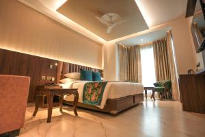 Habitación de hotel con cama y mesa en Hotel RJ - Managed by AHG, en Greater Noida
