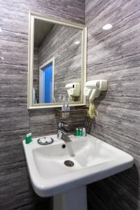 y baño con lavabo blanco y espejo. en Best Center Boutique Hotel en Baku