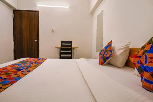 a bedroom with a bed and a table and a chair at FabHotel Saubhagya Elite in Nashik