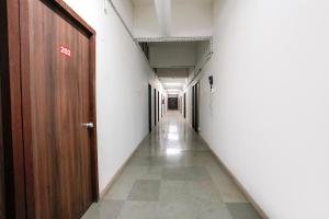 ein leerer Flur in einem Bürogebäude mit einer Tür in der Unterkunft FabHotel Saubhagya Elite in Nashik