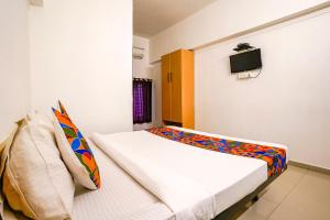 ein Schlafzimmer mit einem Bett und einem TV an der Wand in der Unterkunft FabHotel Saubhagya Elite in Nashik