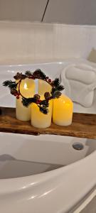 zwei Kerzen auf einem Holztablett in einer Badewanne in der Unterkunft Ma Maison d'Autre 