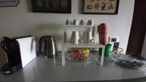 a counter top with a coffee maker and a shelf with vases at IL MERLO CODERLO in Scorcetoli