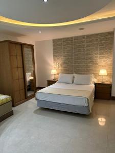 een slaapkamer met een groot bed en 2 lampen op tafels bij Rentrific in Caïro