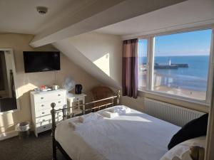 a bedroom with a bed and a large window at The Mariners House in Scarborough