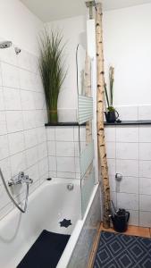 a bathroom with a bath tub with plants on the wall at Ferienwohnung Haus Schöneck in Schönecken