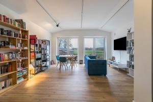 een woonkamer met een tafel en boekenplanken bij Willewatt Wohnung 1 in Husby