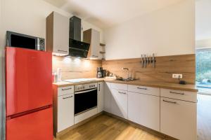 a kitchen with a red refrigerator and white cabinets at Willewatt Wohnung 1 in Husby