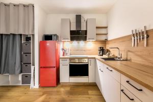een keuken met een rode koelkast en witte kasten bij Willewatt Wohnung 1 in Husby
