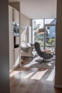 uma sala de estar com uma cadeira e um sofá em Ostsee - Reetdachhaus Nr 38 "RIKE" im Strand Resort em Heiligenhafen