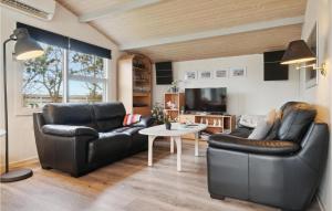 uma sala de estar com duas cadeiras de couro e uma mesa em Gorgeous Home In Thisted With Wifi em Thisted