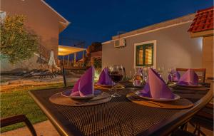 - une table avec des serviettes violettes et des verres à vin dans l'établissement 1 Bedroom Nice Apartment In Karalic, à Širitovci