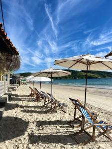 a row of chairs and umbrellas on a beach at Orlanova Hotel in Arraial do Cabo