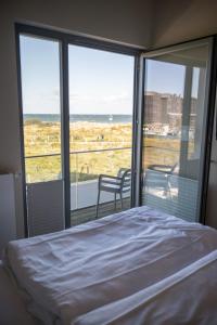 a bedroom with a bed and a view of the ocean at Ostsee - Reetdachhaus Nr 37 "RENATE" im Strand Resort in Heiligenhafen