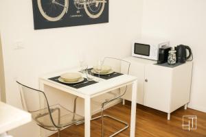 un piccolo tavolo bianco con sedie e forno a microonde di HT - Elegante mini in Prato della Valle a Padova Altre 5 foto