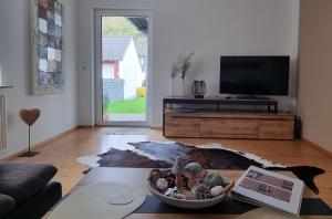 a living room with a television and a table at Ferienwohnung Familie Buchner in Großheubach