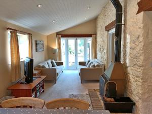 a living room with a wood stove in a room at Finest Retreats - Little Dunley - Lake View in Bovey Tracey