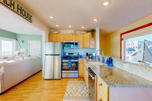 a kitchen with a stainless steel refrigerator and a couch at Sea Scallop in Pacific Beach