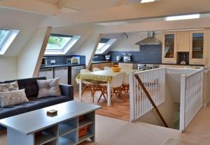 a kitchen and living room with a couch and a table at Finest Retreats - Little Dunley - Vine Lodge in Bovey Tracey