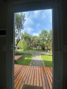 a door to a porch with a view of a yard at Amapola Tiny House in San Carlos de Bariloche