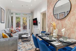 uma sala de estar com uma mesa e cadeiras azuis em Gorgeous 3-bedroom in London - Sleeps 8 em Londres