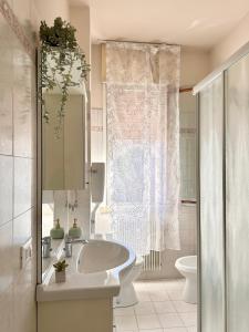 a white bathroom with a sink and a toilet at Casa TOÈ in Conegliano