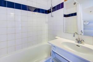 W łazience znajduje się biała wanna i umywalka. w obiekcie Vacancéole - Le Borsat IV w mieście Tignes