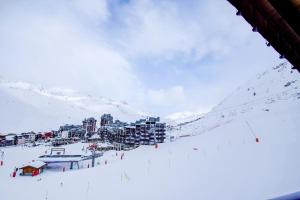 una estación de esquí en la nieve con un remonte en Vacancéole - Le Borsat IV, en Tignes