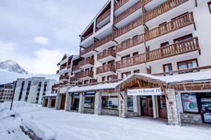 un edificio con nieve en el suelo delante de él en Vacancéole - Le Borsat IV, en Tignes