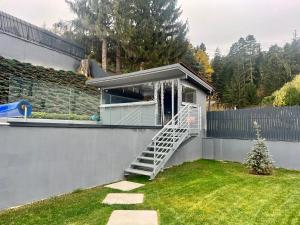 una casa con una escalera en un patio en HELIOS Boutique Hotel, en Săcele