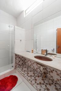 a bathroom with a sink and a mirror at Casa Branca 355 Familiar in Rio de Janeiro