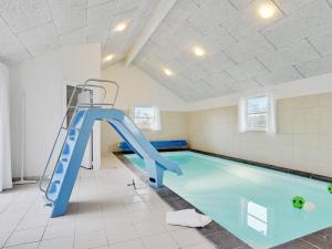 una piscina con un tobogán azul en una habitación en 24 person holiday home in Idestrup, en Bøtø By