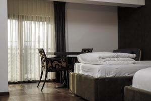 Uma cama ou camas num quarto em Triumf Hotel
