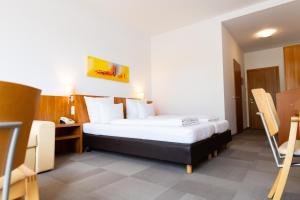 a hotel room with a bed and a desk at Hotel Darstein in Mannheim