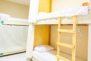a bunk bed with a ladder in a room at Makeba Hostel in Pipa