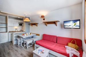 a living room with a red couch and a kitchen at Vacancéole - Le Borsat IV in Tignes +43 photos