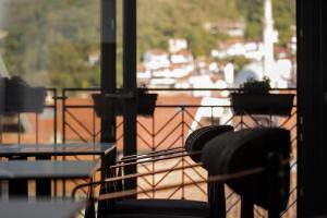 balcón con sillas y mesa y vistas al puerto en Triumf Hotel en Prizren