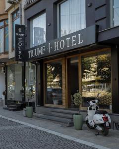 uno scooter parcheggiato di fronte a un hotel di Triumf Hotel a Prizren