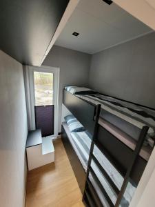 een kamer met 2 stapelbedden en een raam bij Ferienhaus Aurora, Sauna, Seeblick, angeln in Twist