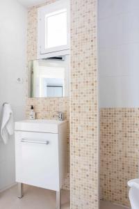 a bathroom with a white sink and a mirror at Old Port, apartamento con vistas al puerto in Bermeo +42 photos