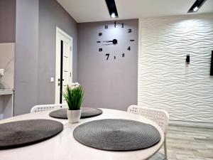 a dining room with a table and a clock on the wall at Premium apartment on Belvedere in Ivano-Frankivsʼk